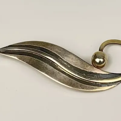 Vintage mid-century Sterling Silver  wave brooch featuring dark oxidized grooves and a polished bead accent.
