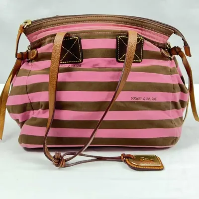 Dooney & Bourke pink and brown striped canvas shoulder bag featuring tan leather trim, double handles, and brass hardware.