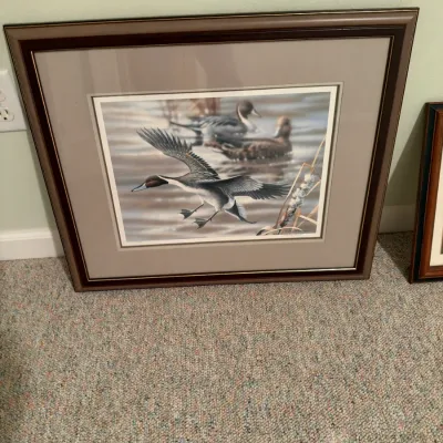 Framed waterfowl art print featuring pintail ducks over water, double-matted in a dark wood frame.