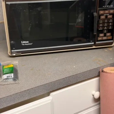 Vintage Litton "Go-Anywhere" microwave oven featuring a cream and brown casing with a digital keypad, circa 1980s.