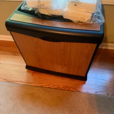 Vintage Bemis console-style humidifier featuring a faux-woodgrain cabinet and dark trim, topped with unopened replacement filters.