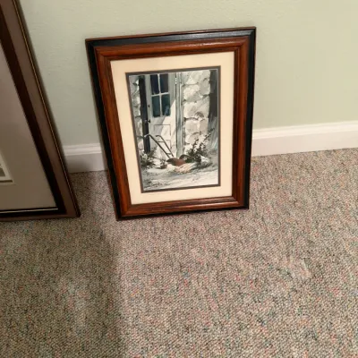 Framed watercolor print depicting a rustic doorway scene, housed in a molded wood frame with a cream mat.