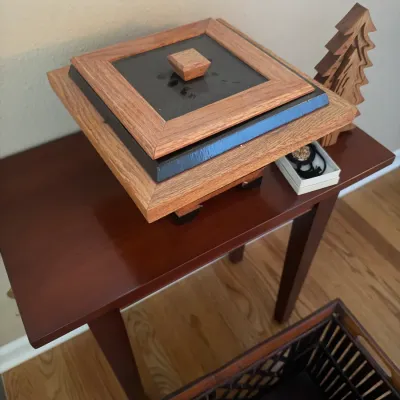Handcrafted mixed-wood and black accent decorative trinket box, displaying multi-tiered construction and a square lid handle.