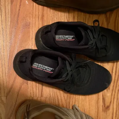 Pair of black Skechers BOBS Memory Foam sneakers in gently used condition, resting on a hardwood floor.