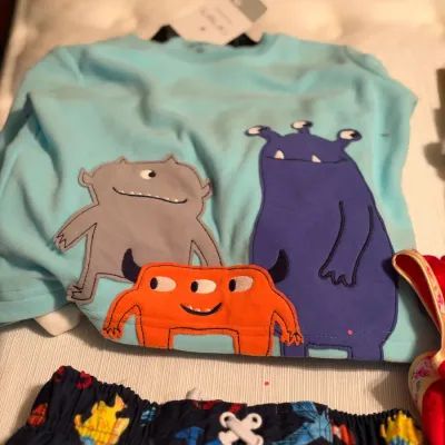 Light blue Carter's long-sleeve toddler shirt with monster appliqués, size 3T, with original store tags attached.