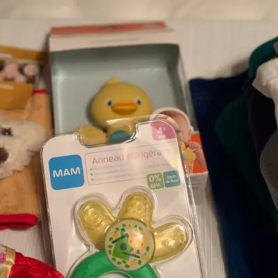 Selection of baby items including a MAM cooling teether ring in original packaging and a boxed yellow duck toy.