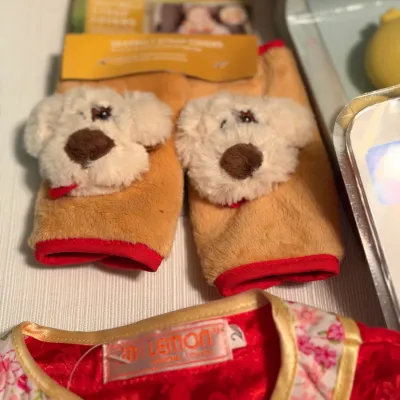 Plush dog-themed Jeep car seat belt strap covers in original packaging alongside a red floral-trimmed garment.