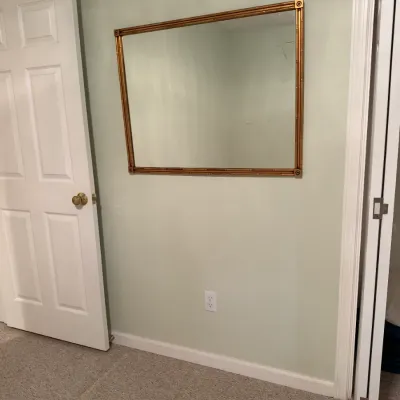 Large rectangular wall mirror in a faux-bamboo gilt frame with corner rosettes.