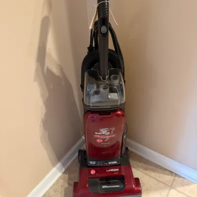 Hoover Supreme WindTunnel bagged upright vacuum cleaner in burgundy plastic casing.