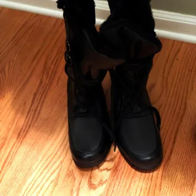 Pair of black lace-up winter boots featuring faux fur trim along the collars.