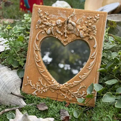 Sale Photo Thumbnail #198: Vintage cherub resin picture frame with a heart-shaped opening and ornate relief floral detailing.