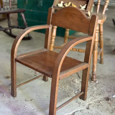 Sale Photo Thumbnail #272: Vintage child's oak armchair with curved arms and a shaped splat back.