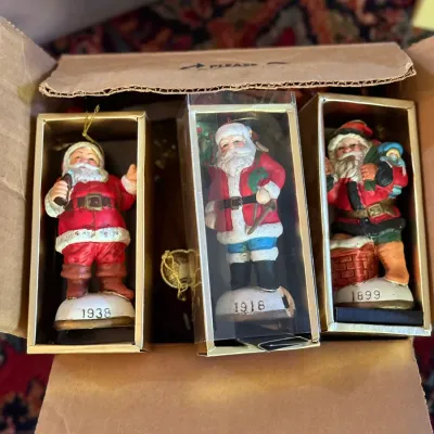 Sale Photo Thumbnail #67: Trio of vintage Coca-Cola heirloom Santa Christmas ornaments in original boxes, depicting Santa designs from 1938, 1918, and 1899.
