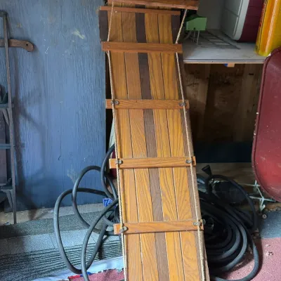 Sale Photo Thumbnail #234: Vintage wooden toboggan sled featuring multi-tone wooden slats, side ropes, and cross-brace support bars.