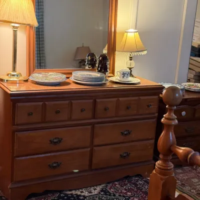 Sale Photo Thumbnail #24: Traditional wooden double dresser with matching attached mirror, featuring six large drawers and four smaller upper drawers, displayed with lamps and decorative tableware.