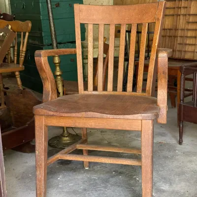Sale Photo Thumbnail #300: Vintage solid oak banker's armchair with a slat back and contoured wooden seat.