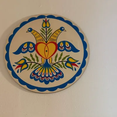 Sale Photo Thumbnail #170: Vintage Pennsylvania Dutch hex sign featuring lovebirds, heart, and floral motifs on a circular plaque.