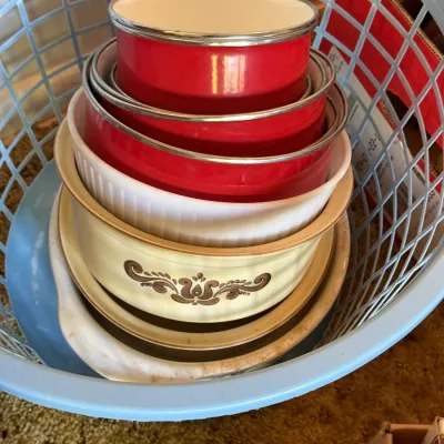 Sale Photo Thumbnail #76: Stacked vintage cookware and bakeware housed in a blue plastic grid basket, including enamel pots and patterned ceramic dishes.