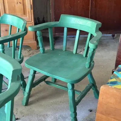 Sale Photo Thumbnail #287: Vintage green-painted captain's armchairs featuring turned wooden legs and spindle backs.