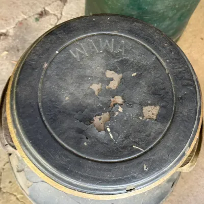 Sale Photo Thumbnail #296: Vintage Wawa branded milk can with embossed metal lid, showing heavy surface wear and paint peeling.