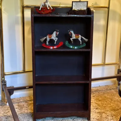 Sale Photo Thumbnail #40: Small dark wood multi-tier bookcase displaying decorative miniature rocking horses and a boxed set of Chinese exercise health balls.