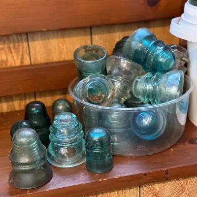 Sale Photo Thumbnail #185: Collection of vintage glass telegraph insulators in various shades of blue, aqua, and clear glass.