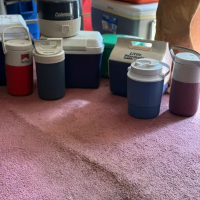 Sale Photo Thumbnail #214: Collection of vintage insulated beverage jugs and coolers, including brands such as Coleman, Iggy Playmate, and Marlboro.