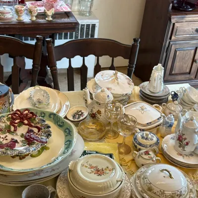 Sale Photo Thumbnail #117: Collection of vintage porcelain and glassware, including floral-patterned teapots, covered casserole dishes, gold-rimmed goblets, and decorative holiday plates.