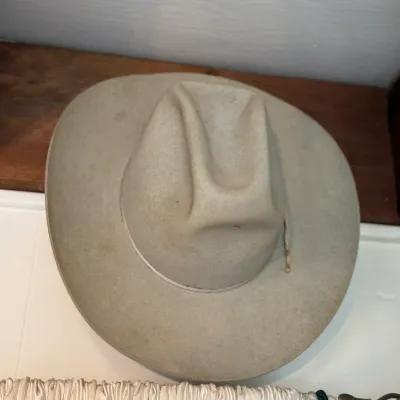 Sale Photo Thumbnail #129: Vintage light beige felt cowboy hat with a cattleman crease, showing minor wear consistent with age.