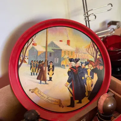 Sale Photo Thumbnail #74: Vintage Adam Scheidt Brewing Co. metal advertising tray featuring an illustration of Washington's Headquarters at Valley Forge, 1777, with a red rim.
