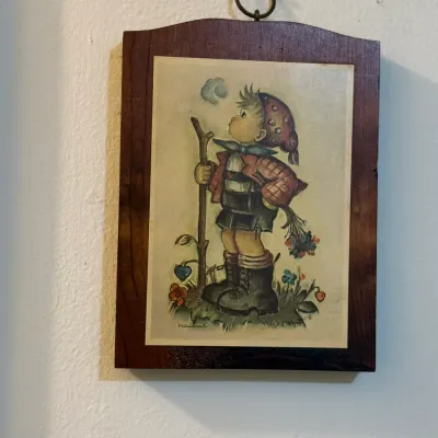 Sale Photo Thumbnail #51: Vintage Hummel-style print depicting a young boy with a walking stick mounted on a dark wooden wall plaque.
