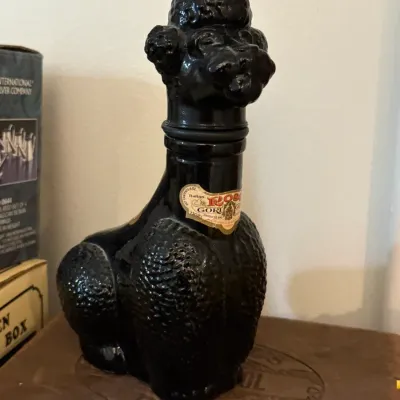 Sale Photo Thumbnail #29: Vintage black glass poodle decanter bottle featuring the original Italian liqueur label on the neck.