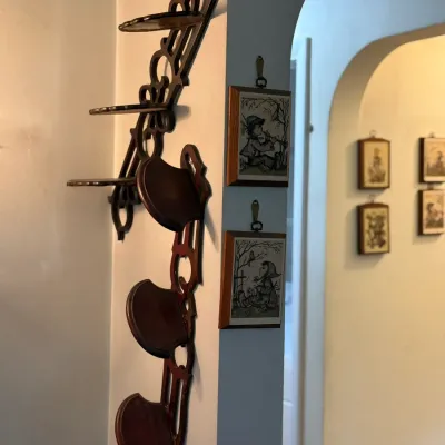 Sale Photo Thumbnail #61: Vintage dark wood openwork wall-mounting display shelves mounted beside small framed wall art graphics.
