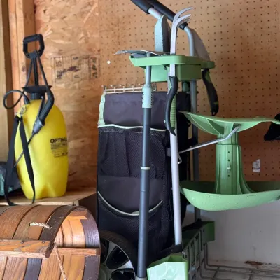 Sale Photo Thumbnail #210: Rolling garden caddy organizer with attached stool and tools, shown alongside a yellow pump sprayer and a wooden slatted basket.