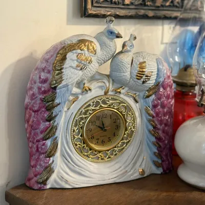 Sale Photo Thumbnail #166: Vintage ceramic mantel clock featuring a pair of sculpted peacocks with gold accents and pink tail feathers.