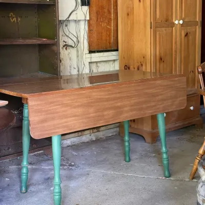 Sale Photo Thumbnail #293: Vintage wooden drop-leaf dining table featuring a natural wood top and turned legs painted green.
