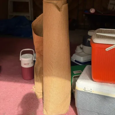 Sale Photo Thumbnail #211: Large roll of tan burlap or carpet padding stored indoors near vintage coolers.