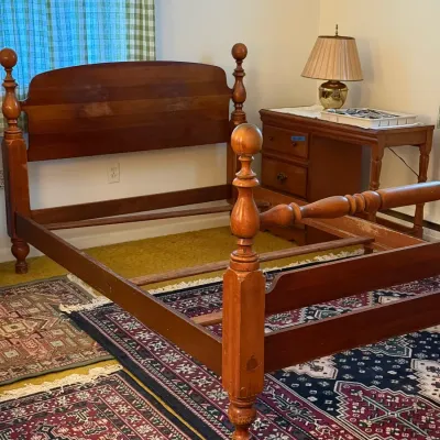 Sale Photo Thumbnail #26: Traditional wooden four-poster bed frame featuring turned ball finials and a arched headboard. A matching nightstand with drawers sits in the background beside a brass table lamp with a pleated shade.