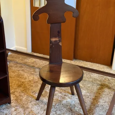 Sale Photo Thumbnail #48: Vintage dark stained wood spinning chair featuring a contoured backrest, round seat, and four splayed legs with visible surface wear to the finish.