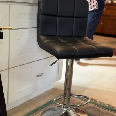 Sale Photo Thumbnail #139: Modern adjustable bar stool with black tufted faux-leather upholstery and a chrome pedestal base.