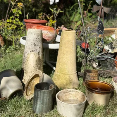 Sale Photo Thumbnail #245: Collection of vintage garden planters, pottery, and stoneware crocks displayed outdoor on grass.