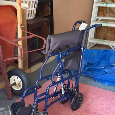 Sale Photo Thumbnail #228: Blue Medline transport wheelchair with black padded seat and armrests, appearing in good, clean condition.
