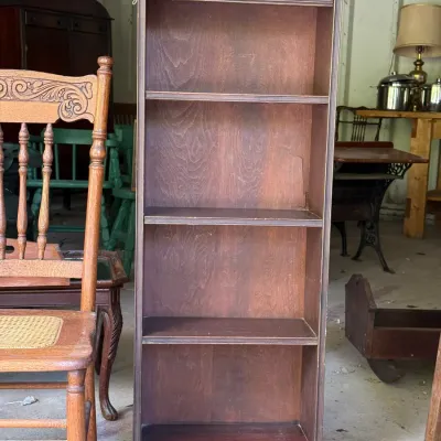 Sale Photo Thumbnail #301: Tall vintage wooden bookcase featuring geometric carved trim detailing along the top and bottom borders.