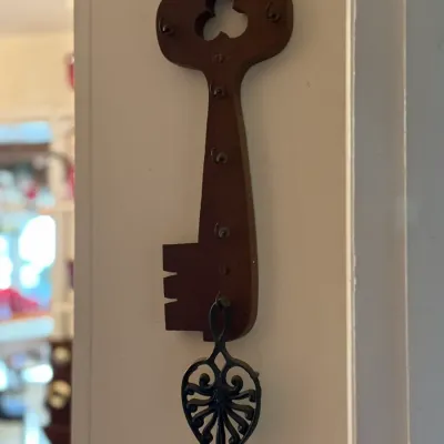 Sale Photo Thumbnail #7: Vintage key-shaped wooden wall rack with small brass hooks, featuring a clover cutout detail.