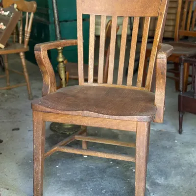 Sale Photo Thumbnail #268: Vintage oak slat-back armchair with curved armrests and a contoured wooden seat, showing surface wear.