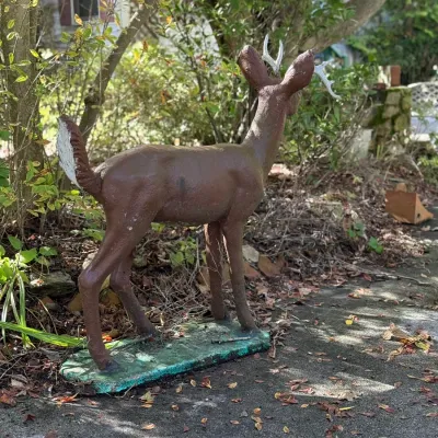 Sale Photo Thumbnail #239: Vintage painted concrete lawn statue of a deer with antlers mounted on an integral base.