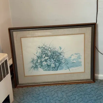 Sale Photo Thumbnail #15: Framed watercolor art print depicting a woven basket filled with wild daisies, grass, and dragonflies, set in a wood and linen-matted frame.