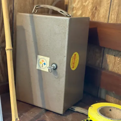 Sale Photo Thumbnail #186: Vintage metal cash box with top handle and key included, featuring a Pittsburgh Steelers logo sticker.