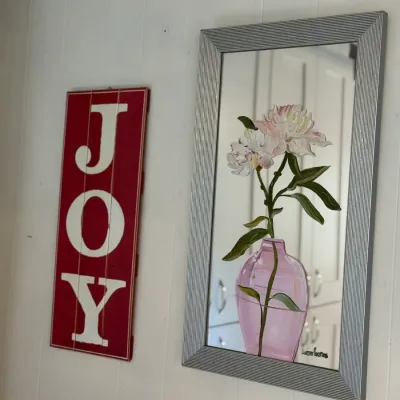 Sale Photo Thumbnail #141: Hand-painted floral mirror in a ribbed silver-tone frame alongside a red wooden vertical 'JOY' wall sign.