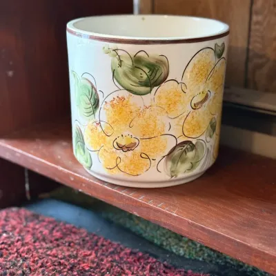 Sale Photo Thumbnail #177: Vintage ceramic planter featuring hand-painted yellow flowers and green leaves with a brown rim.